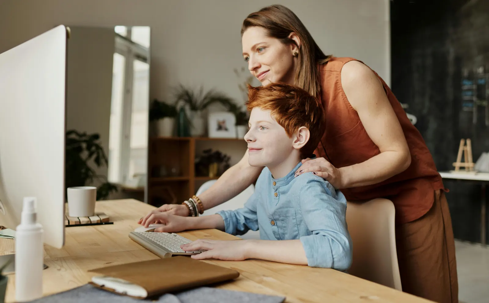 A parent and child learning together at a computer